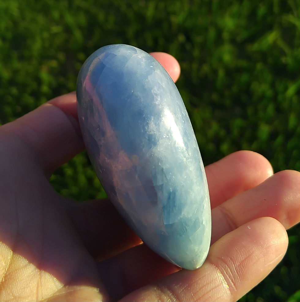 Thumbnail: Hand holding a puffy Blue Calcite crystal heart outdoors.