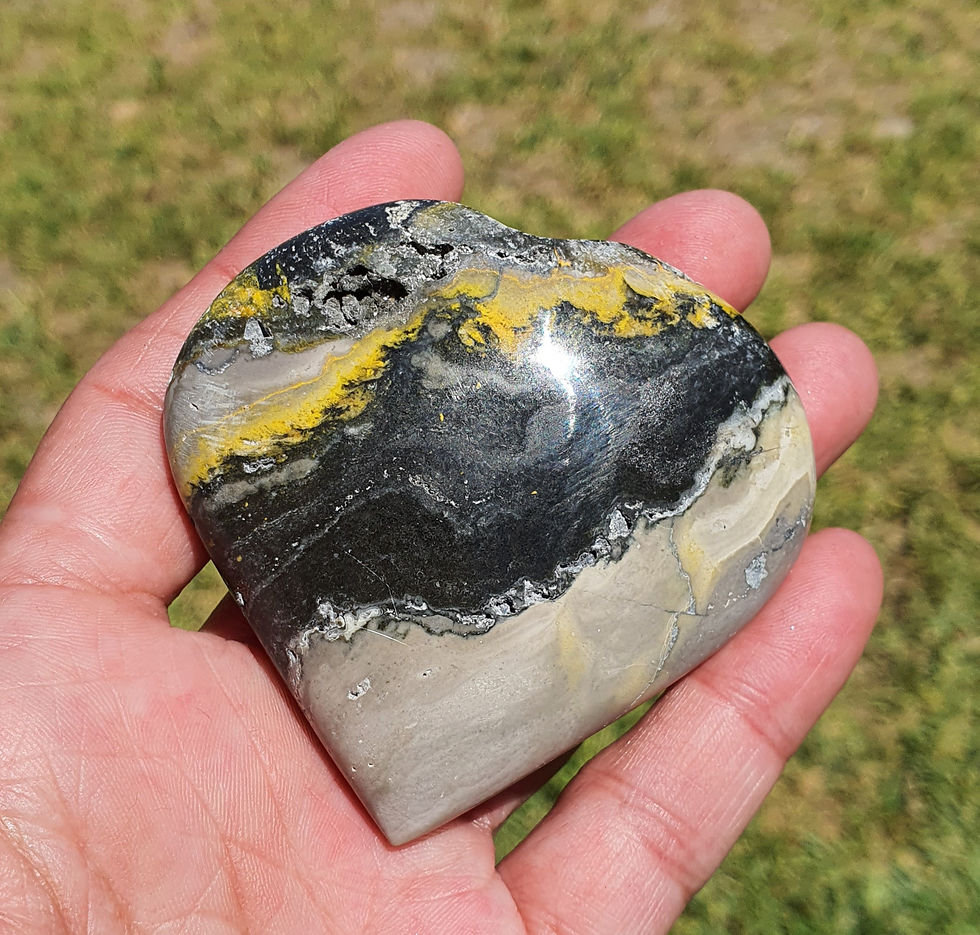 Hand holding a Bumblebee Jasper puffy crystal heart.