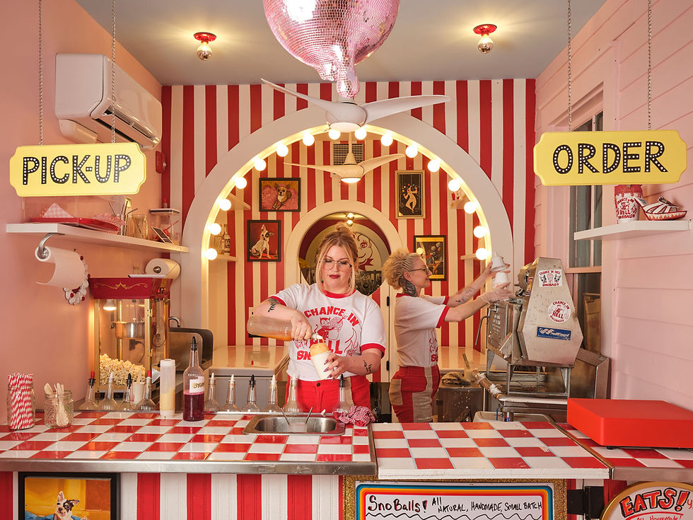 narrow shop with red and white circus striped snoball counter in the back and a group of people eating snoballs or waiting in line