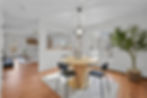 Open-concept dining area with neutral tones and greenery