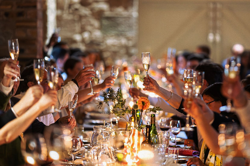 Guests raising champagne flutes for a toast at a formal dinner event at The Border Barn_ed