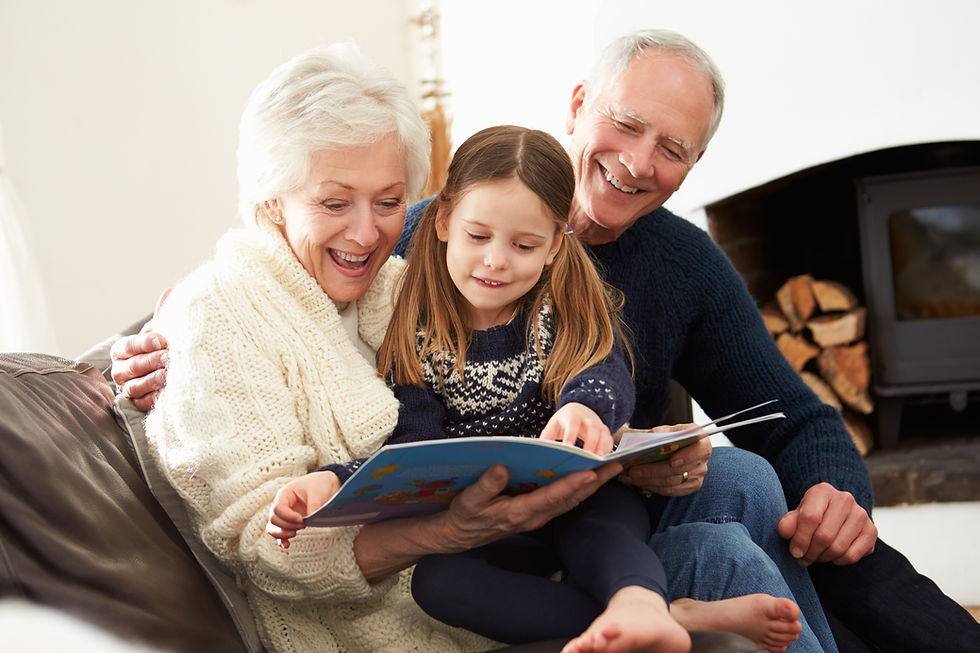 Grandparents and grandchild reading a book together at home.