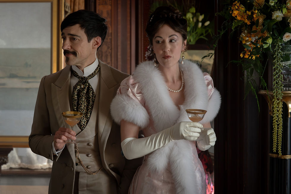 Elegant couple in vintage formalwear holding cocktails in a wood-paneled room, with flowers and a refined, reserved mood