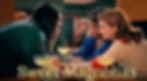 Three women smile and lean in together over a table with margaritas. Cozy setting with warm lighting. Text: Sweet Magnolias.