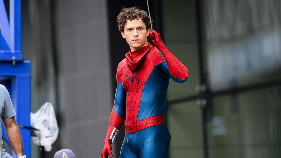 Spider-Man in red and blue suit holds web, looking focused, against a modern building backdrop.