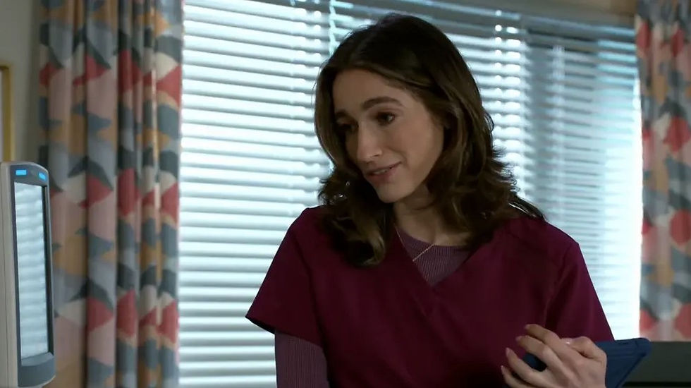 Woman in maroon scrubs holding a tablet, smiling in a room with colorful curtains and blinds. Mood is warm and professional.