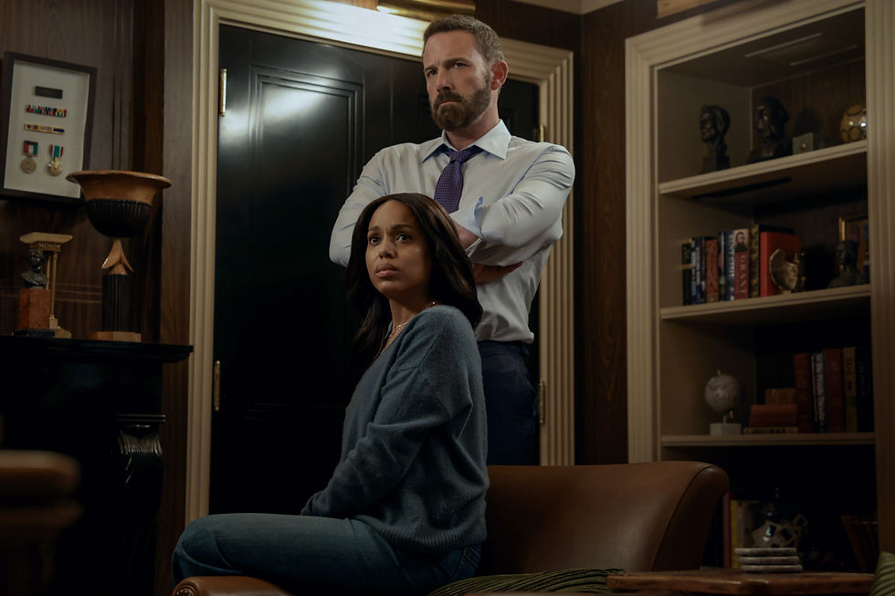 Serious man stands behind a seated woman in a wood-paneled office, with bookshelves and awards in the background.