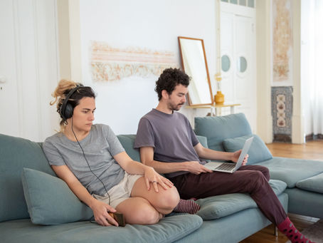 A couple sitting on a sofa not communicating