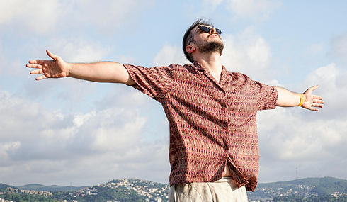 Man with arms wide open, looking at sky, feeling free.