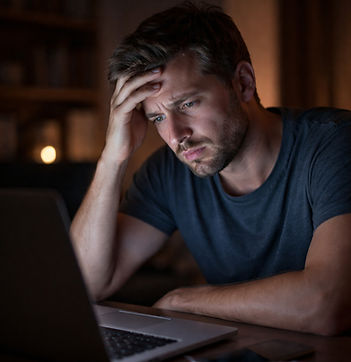 Distressed man looking at a laptop