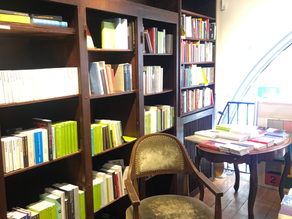 une chaise derrière une table et une bibliothèque pleine de livres