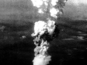 Nuage en champignon d'une explosion, s'élevant dans le ciel, fond sombre. Atmosphère dramatique. Aucune personne visible.