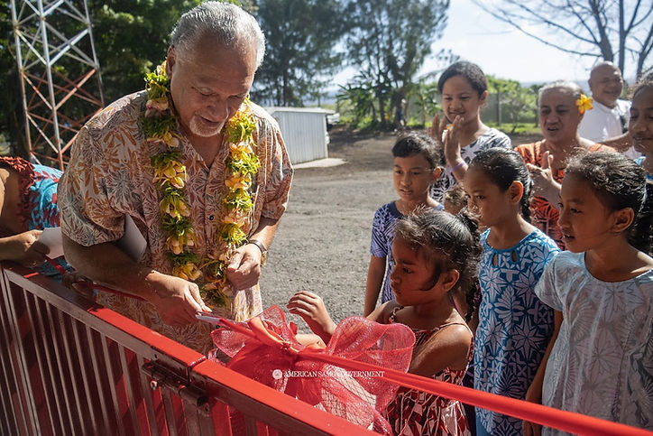 A group of smiling students joins the Governor in a celebratory ribbon cutting ceremony.jp