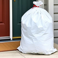white 13 gallon trash bag with red draw strings tied and set outside by the front door_edi