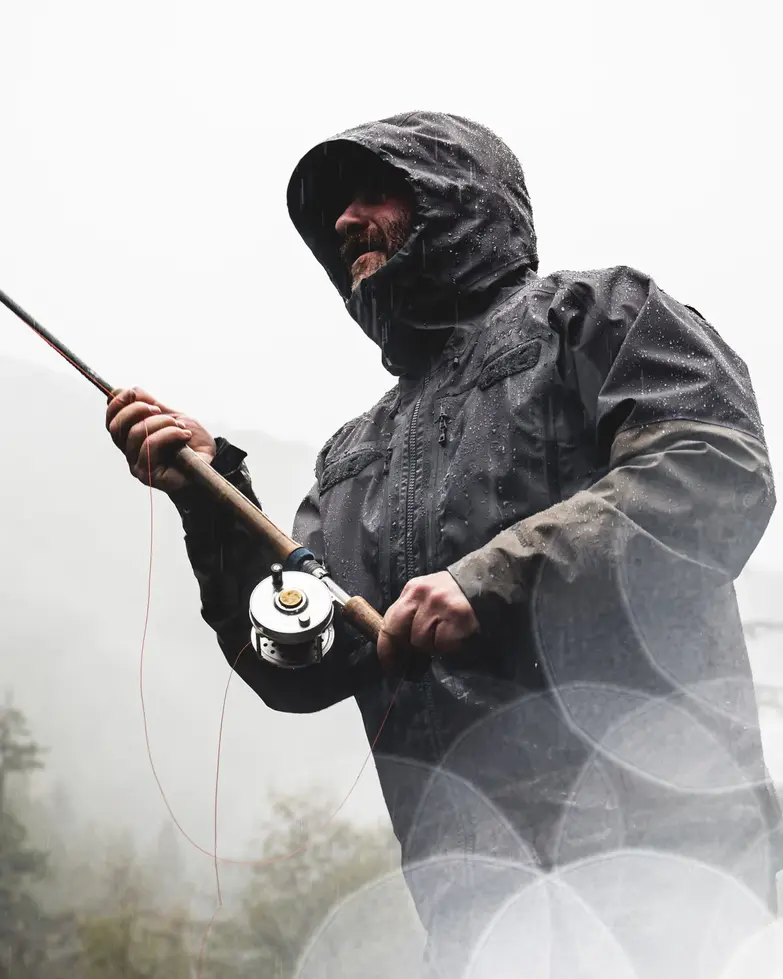Pêcheur en veste Simms G3 Guide sous la pluie.