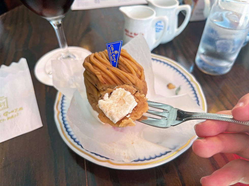 A close-up of the mont blanc, holding it up on a fork so the whipped cream and meringue layer is revealed.