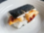 A chicken onigirazu on a white plate from the convenience store.
