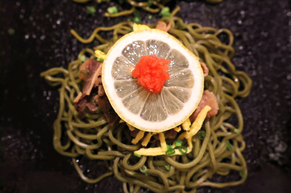 A birds-eye close up of the Kawara Soba from Buchi Izakaya topped with lemon.