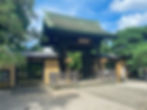 The entrance of Gotokuji Temple in Tokyo, with a green tiled roof.