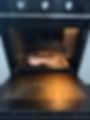 Open oven with food baked on stains