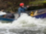 Paddler in a red helmet practicing open canoe coaching.