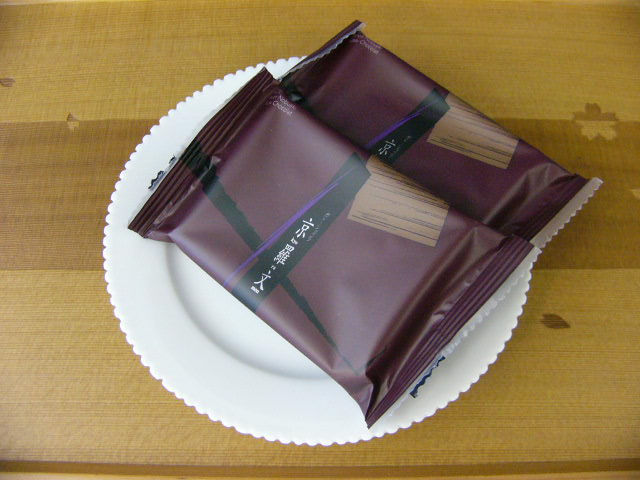 皿に乗せた、紫色の包装のチョコレート菓子の個包装二つ