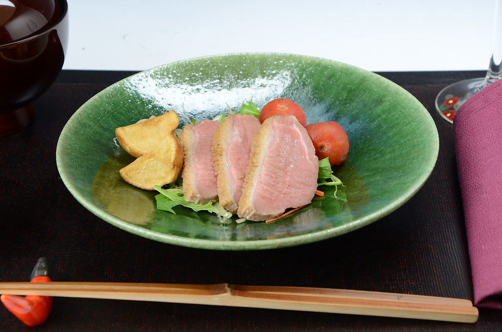 緑色の釉薬の浅鉢に、鴨ロースとトマトを盛り付けた料理