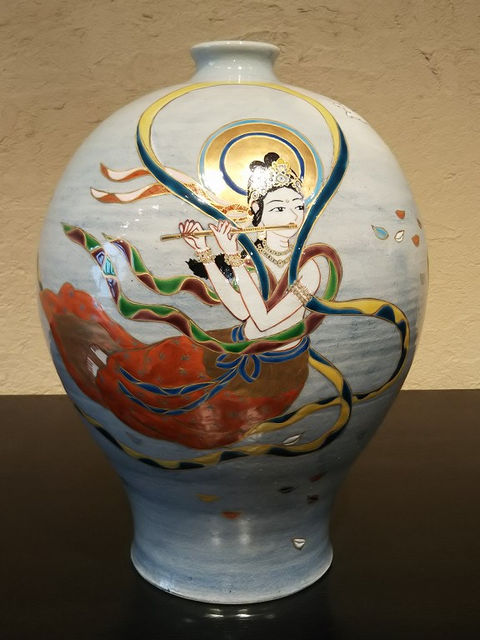 笛を吹く天女を描いた色絵の壺。青みがかった地に金の光背