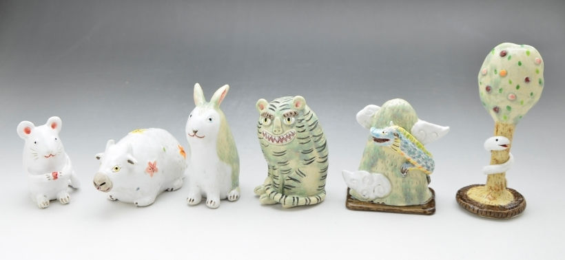 ネズミ、猪、ウサギ、トラ、羽の生えた山、蛇が巻き付いた木が並ぶ光玉作品の干支の置物
