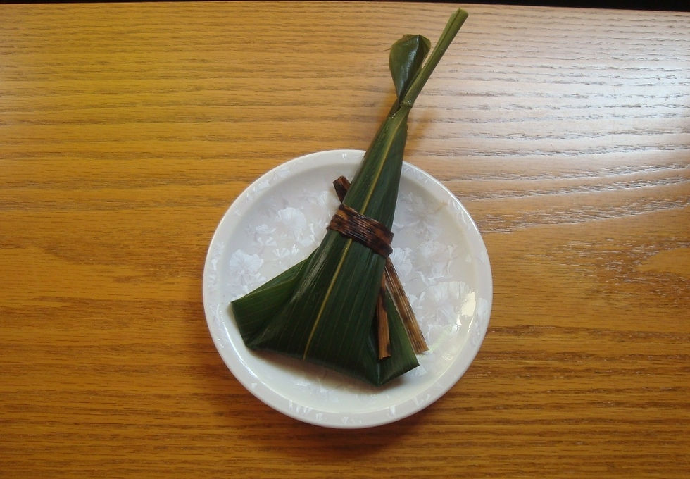笹の葉で包み、氷を敷いた白い小皿にのせた和菓子