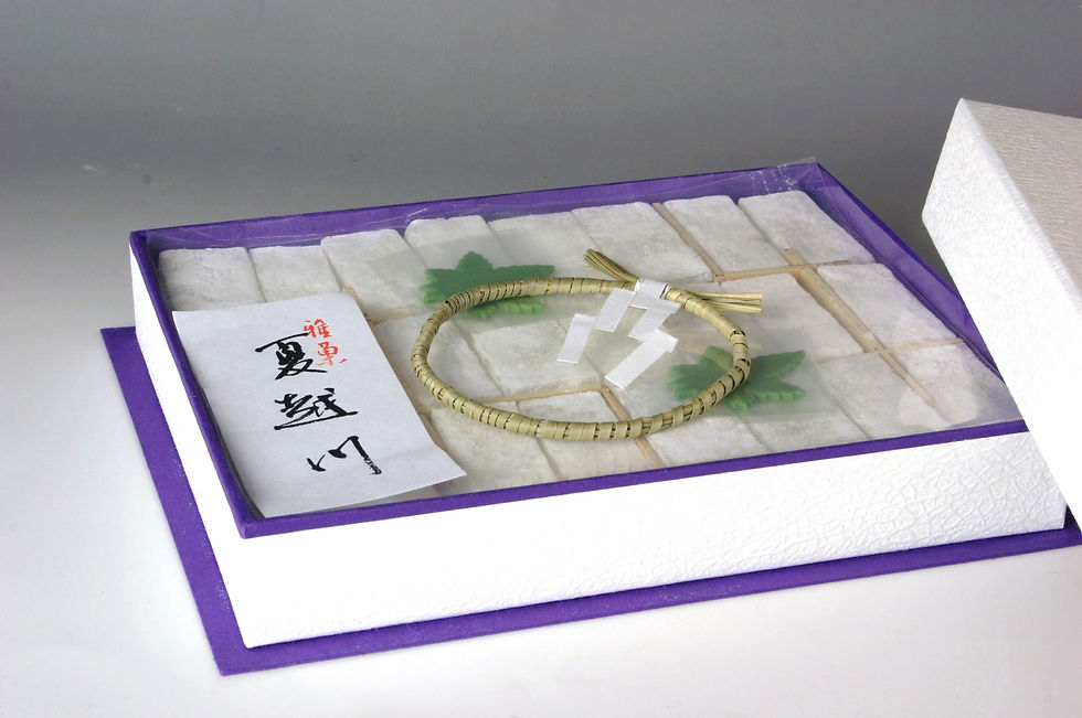 紫の縁取りの箱に入った水無月風の涼菓。「夏越川」と書かれた紙と茅の輪