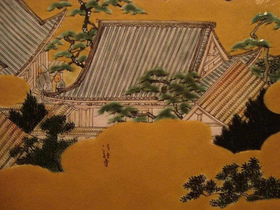金地に瓦屋根の社寺と松を描いた色絵の絵付け