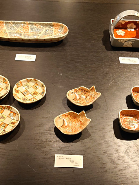 内田裕子陶展にて展示された、だるまや鯛などが描かれた多彩な和食器