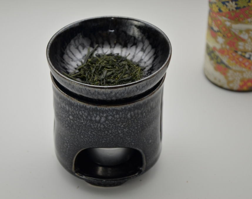 茶香炉の皿に茶葉をのせた様子。奥に千代紙の茶缶
