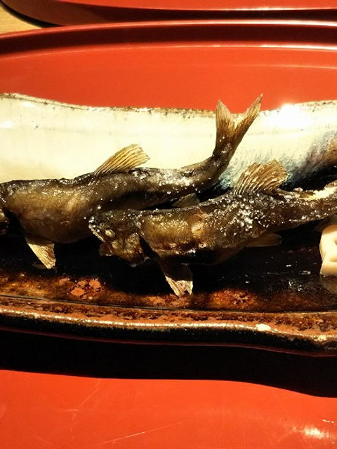 たん熊の鮎の塩焼き。赤い漆の盆に焼き物の長皿とレンコン