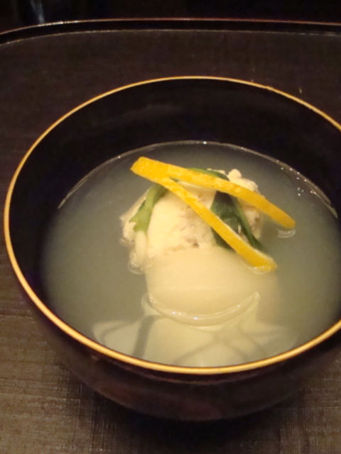 金縁の黒い椀に入った吸い物、柚子の皮と青菜をあしらった