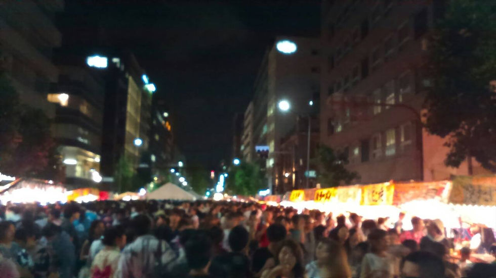 夜の通りに屋台が並び、浴衣姿の人々でにぎわう祇園祭の宵山