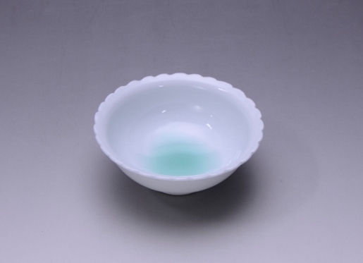 輪花の縁に翡翠色が溶けるように入った白磁の小鉢を斜め上から見たところ