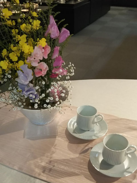 テーブルに飾った春の花とコーヒーカップ二客