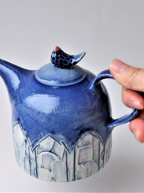 青い小鳥のつまみが付いた陶器のティーポット