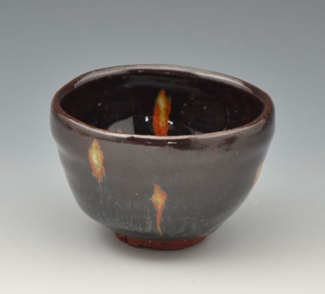 黒い鉄釉に橙色の飛び模様が入った酒盃