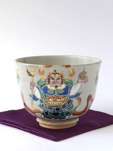 紫の帛紗に置かれた毘沙門天が描かれた抹茶碗
