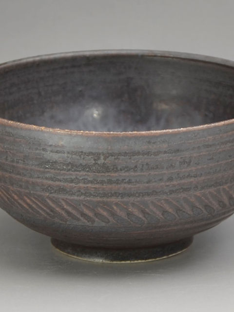 すじ彫りと斜めの刻み模様が入った黒褐色マット釉の飯碗