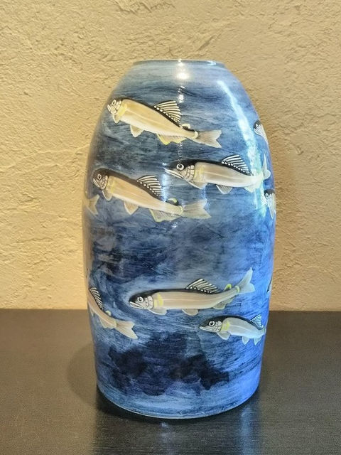 青い釉薬の地に鮎が泳ぐ姿を描いた壺