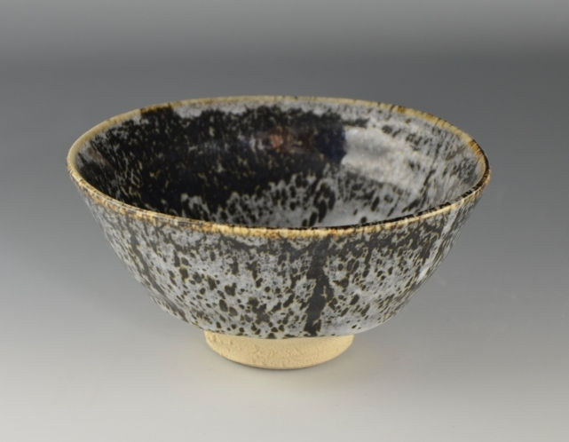 黒地に白い裂けるような釉薬が広がる茶盌