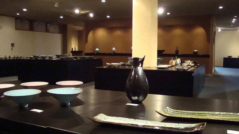 黒いテーブルに水色の鉢や長皿、黒い花入が並ぶ兄弟展の会場風景