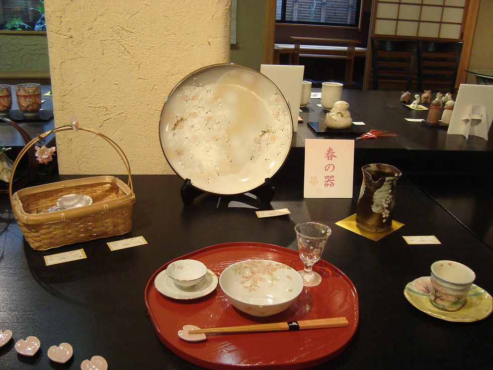 「春の器」の札のもと、桜柄の大皿・飯碗・グラスを漆の盆にのせた展示