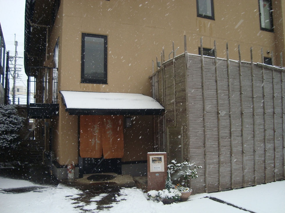 雪が降る中、暖簾の掛かった洛中洛外の入口