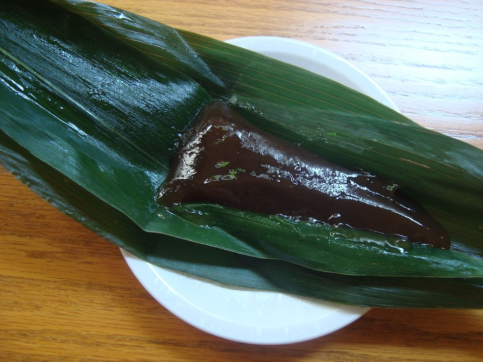 笹の葉をほどいて見せた、つやのある黒褐色の和菓子