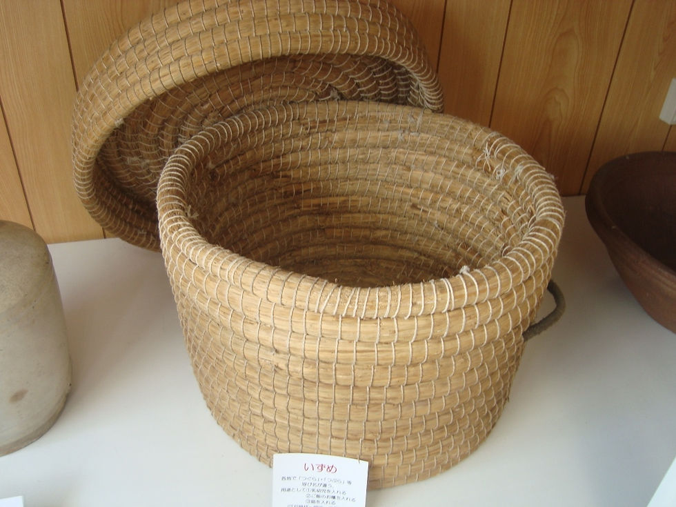 蓋を開けた藁編みの丸いいずめ(嬰児籠)